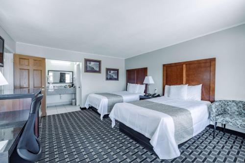 杰克逊Travelodge by Wyndham Jackson North的酒店客房,配有两张床和椅子