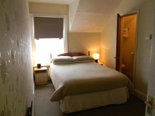布莱克浦Dora Hotel的一间卧室设有一张大床和窗户