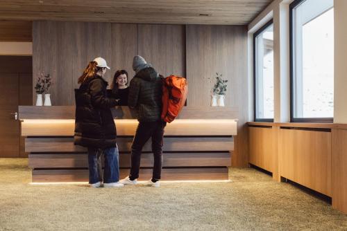 库哈台Hotel Lisl - Alpine Comfort的两个人站在柜台前
