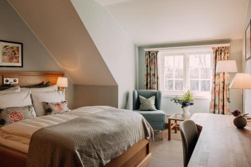 彻默岛Engø Gård Hotel & Restaurant的卧室配有床、椅子和窗户。