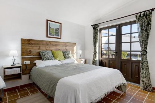 蒂亚斯Casa Los Angeles的一间卧室设有一张大床和一个窗户。