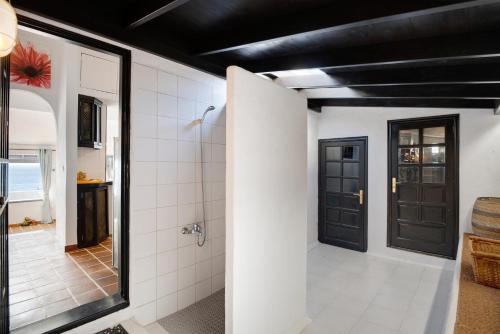 蒂亚斯Casa Los Angeles的设有带步入式淋浴间和黑色门的浴室
