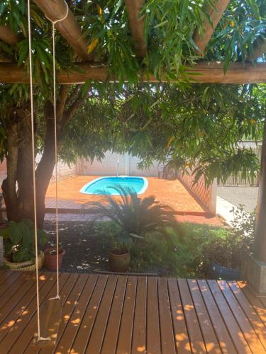 伊瓜苏Suíte Maciel的一个带木甲板的庭院内的游泳池