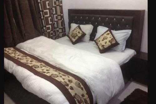 阿格拉Kaka Ji Palace By WB Inn的一张配有白色床单和枕头的大床