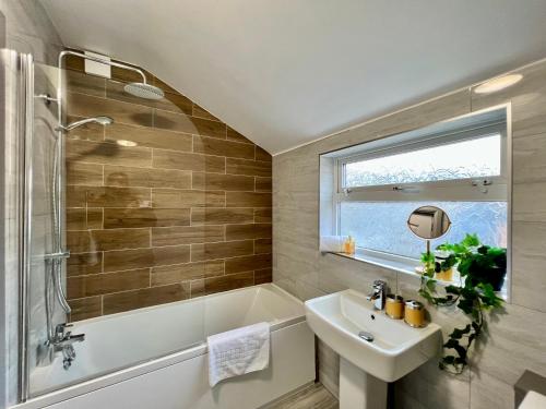 克利索普斯Bramhall House - Great for Contractors or Family Holidays的浴室配有水槽、淋浴、浴缸和水槽。