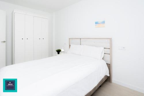阿鲁卡斯Sinda Apartment El Puertillo的白色卧室配有一张带白色床单的大床