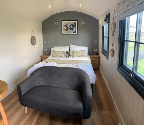 约克Springwood Shepherd Huts Glamping York的一间卧室配有一张床和一张沙发