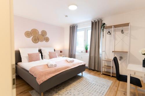 富尔达Peter Apartments - Premium Wohnung I 95qm I 3 Schlafzimmer I großes Bad I Küche I Wohnzimmer I TV的一间卧室配有一张床、一张书桌和一个窗户。