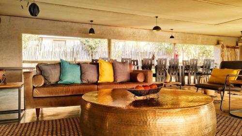 ChobeXhabe Safari Lodge Chobe的客厅配有沙发和桌子