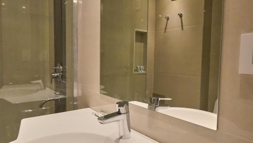 富内斯Ferrol Apart Hotel的浴室配有盥洗盆、镜子和浴缸