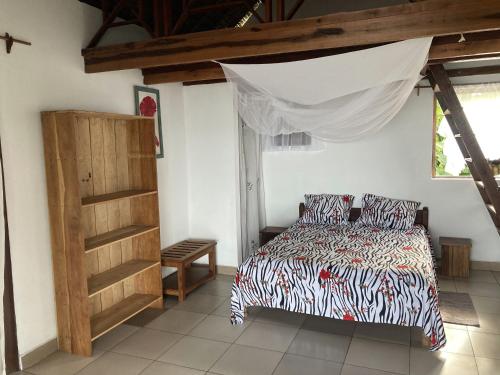 MangalimasoMaison bord de mer的一间卧室配有一张床和一个木制橱柜