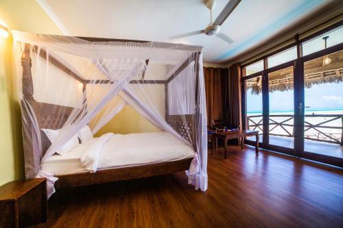 江比阿Mahi Mahi Beach Hotel的一间卧室设有一张天蓬床,享有海景