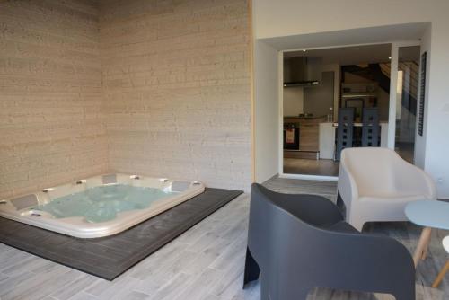 SavasGîte de Laphine avec Spa Privé的按摩浴缸位于客房中间