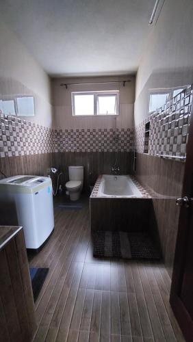SouillacVilla Jehan Tourist Residence的带浴缸和卫生间的大型浴室