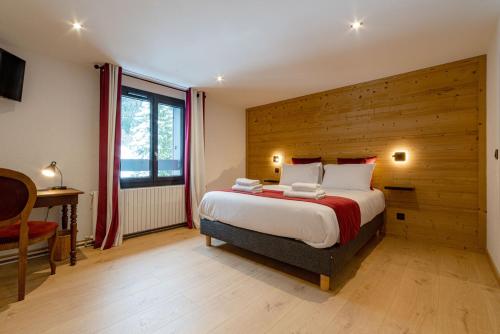 拉费里耶尔Hôtel Restaurant Le Madame的一间卧室设有一张带木墙的大床
