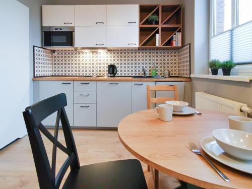 比得哥什Stara Drukarnia - Apartamenty typu Studio的一间带木桌的厨房和一间餐厅