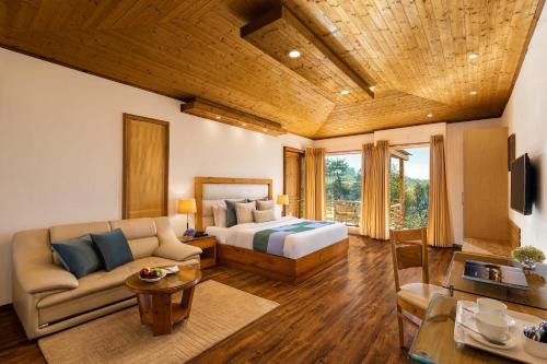 马拉里Baragarh Resort & Spa, Manali- IHCL SeleQtions的一间卧室配有一张床和一个沙发