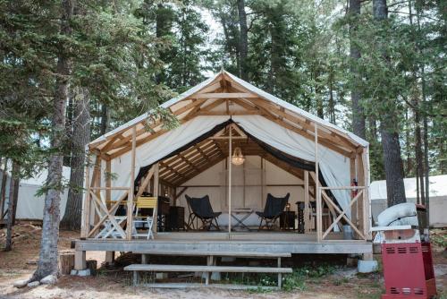 Sundridge北岭度假酒店的树林中带椅子和桌子的帐篷