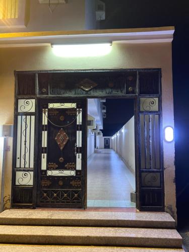 乌姆莱季AlSultan Apartments的通往走廊的开放式门,设有楼梯