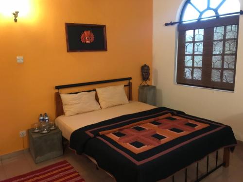 科伦坡微风天堂酒店的一间卧室设有一张床和一个窗口