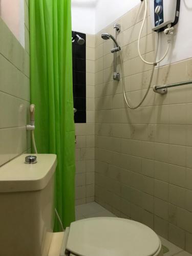 科伦坡微风天堂酒店的一间带绿色淋浴帘和卫生间的浴室