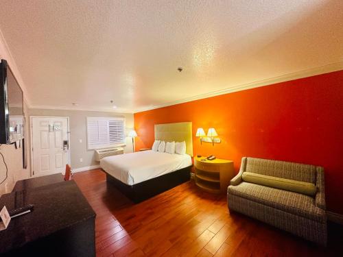 奥兰治Casa Blanca Hotel & Suites Orange SR-55 Freeway, Near Honda Center, Chapman University, Disneyland的酒店客房,配有床和沙发