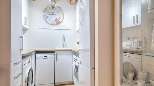 莱斯Saplan Real Estate CARLAC的厨房配有白色家电和墙上的时钟