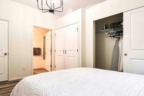北湾Si View的一间白色卧室,配有一张床和一个衣柜