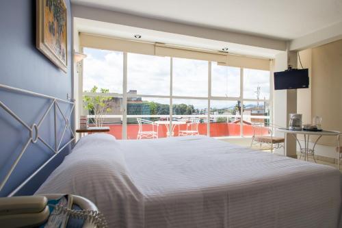 贾拉普巴尔空德尔阿尔福利兹酒店的卧室设有白色的床和大窗户