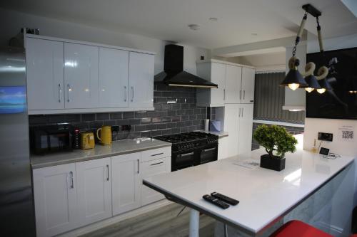 曼彻斯特Rostron House的厨房配有白色橱柜和白色台面