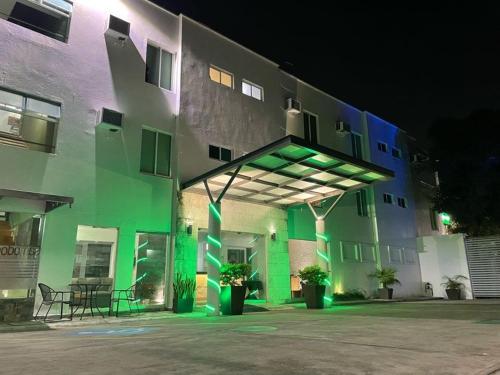 比亚埃尔莫萨Hotel Santo Domingo Express的一座晚上有绿灯的建筑
