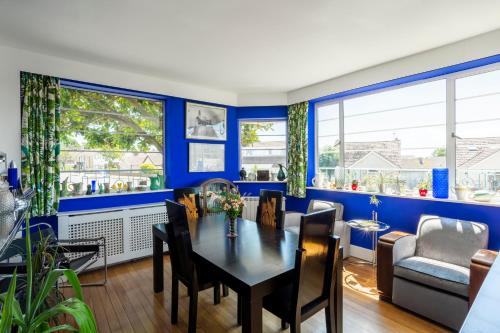 伯青顿Twentieth Century B&B的一间拥有蓝色墙壁和桌椅的用餐室