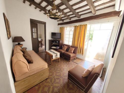 圣弗朗西斯科德尔蒙特蒙奥罗Casa Sarmiento的客厅配有沙发、椅子和电视