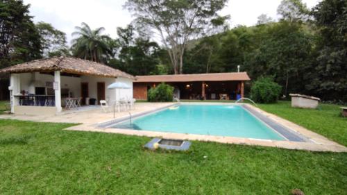 伊泰帕瓦Pouso Donana Cama e Café的一座房子的院子内的游泳池