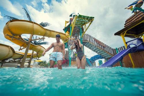 ArraijÃ¡nApartamento vacacional - disfruta playa y toboganes a 32km de la ciudad的站在水上公园的水中的男女