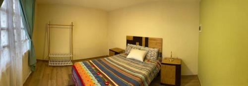 阿雷基帕Katalina's Guest House Arequipa的一间卧室配有一张带五颜六色棉被的床