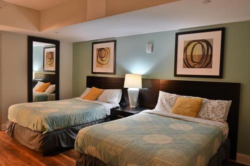 默特尔比奇Spectacular Ocean Front Real 1 Bedroom Condo, 2 Ba的一间卧室设有两张床和一张桌子上的台灯。