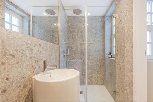 波尔图As Vizinhas Boutique Apartments的白色的浴室设有水槽和淋浴。