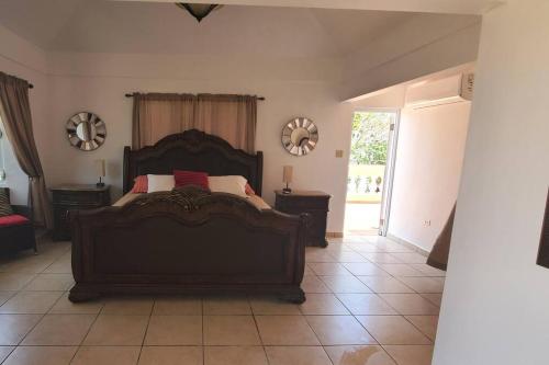 伊莎贝拉Villa Del Carmen Family Vacation Home的一间卧室配有一张大床,配有两张桌子和镜子