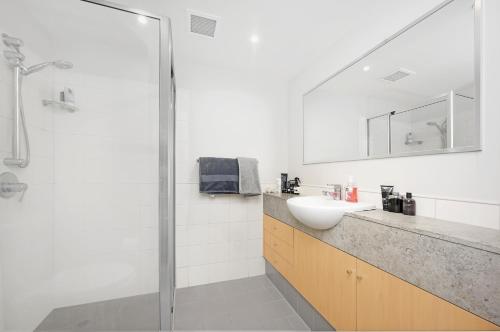 悉尼The Alexander Apartments - Harbour Views, Parking, Pool, 24hr Concierge的一间带水槽和淋浴的浴室