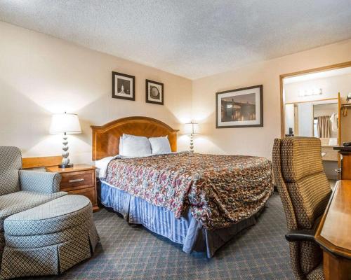 贝克城贝克城罗德威酒店的配有一张床和一把椅子的酒店客房
