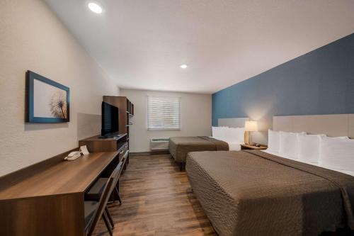 卫斯理堂WoodSpring Suites Wesley Chapel-Tampa的酒店客房设有两张床和一台平面电视。