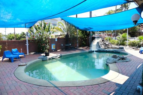 安特兰斯萨普海瑞汽车旅馆的一个带瀑布的游泳池,位于带蓝伞的庭院