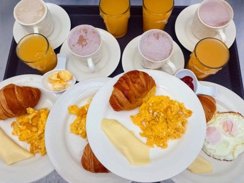 通哈Apartamentos Casa MJ Tunja的餐桌,带早餐盘和橙汁