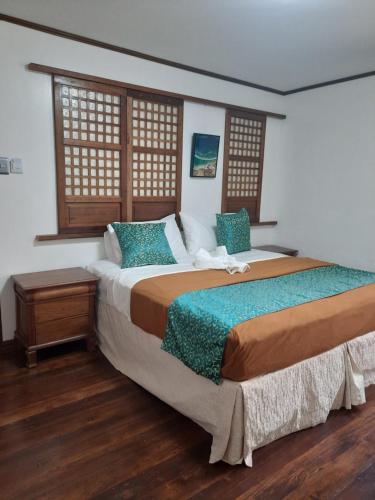 MalabañasBALÉ的一间卧室设有一张大床和两个窗户。