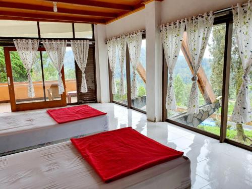 希维德Argapuri Jungle Resort Ciwidey的带大窗户的客房内的两张床