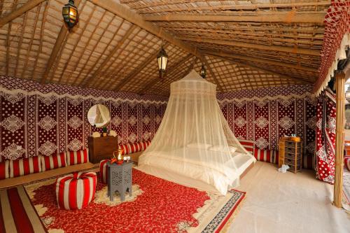 HunaywahAl Khayma Camp "Elite Camping & Dining in Experience"的一间卧室配有一张床和镜子
