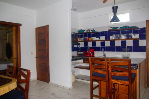 锡瓦塔塔内霍Hotel Happy Beach的厨房的墙壁上铺有蓝色和白色的瓷砖。
