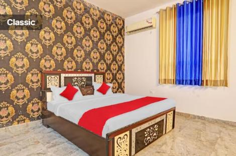 勒克瑙RD Palace and Resort的一间卧室配有红色枕头的床