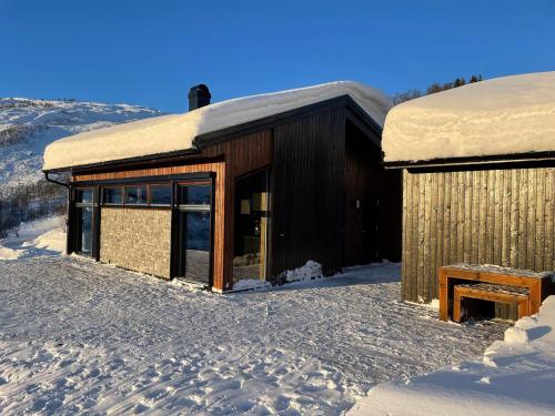 松达尔Cabin at the top of Hodlekve. Ski in/ski out.的雪中,地面上积雪的建筑物